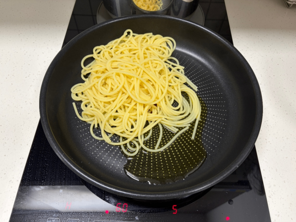 올리브유와 면을 후라이팬 위에서 익히는 사진