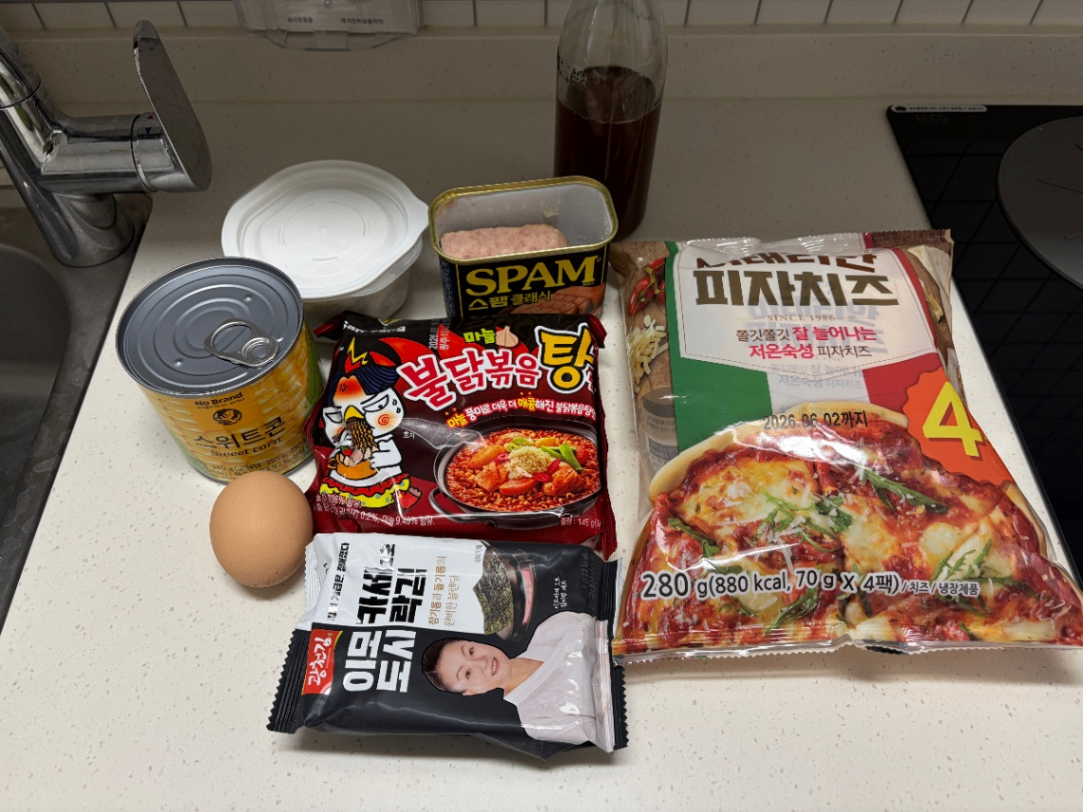 스위트콘, 스팸, 불닭볶음탕면 등의 재료를 올려놓은 사진