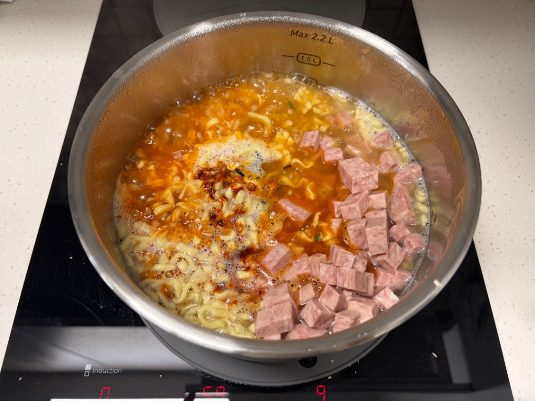 냄비에 액상과 분말 스프, 스팸 등을 넣은 사진