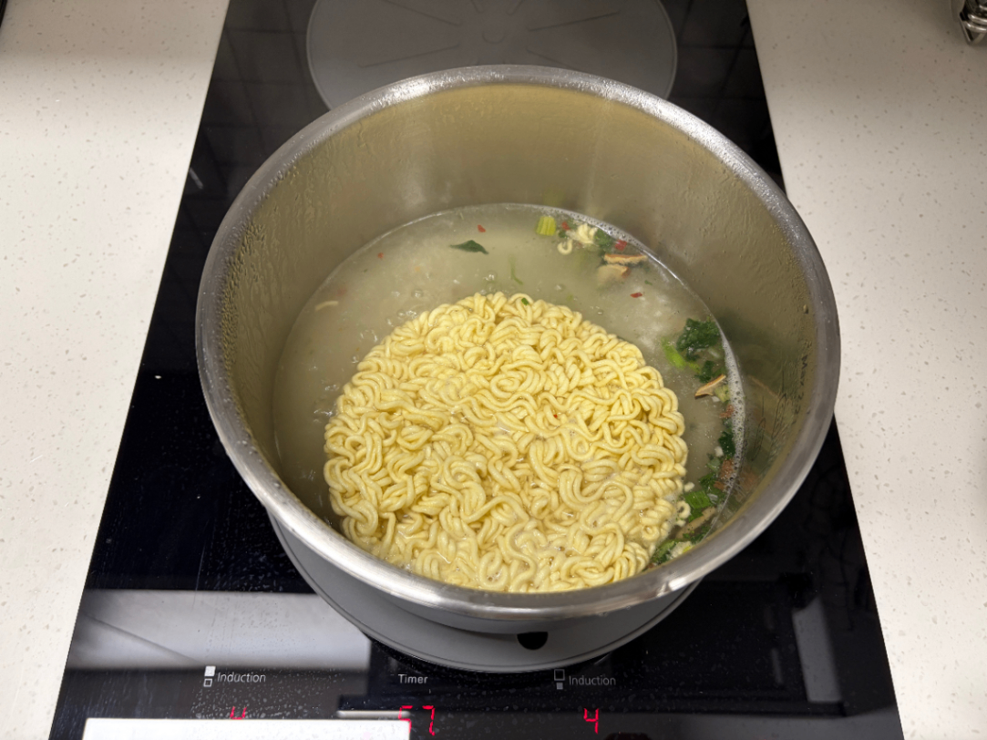 냄비에 물, 라면, 후레이크를 넣고 조리하는 사진