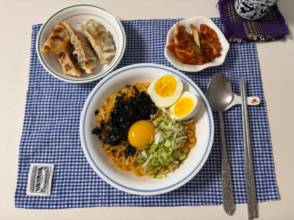 조미김, 노른자, 파 등을 면 위에 올려 플레이팅한 사진